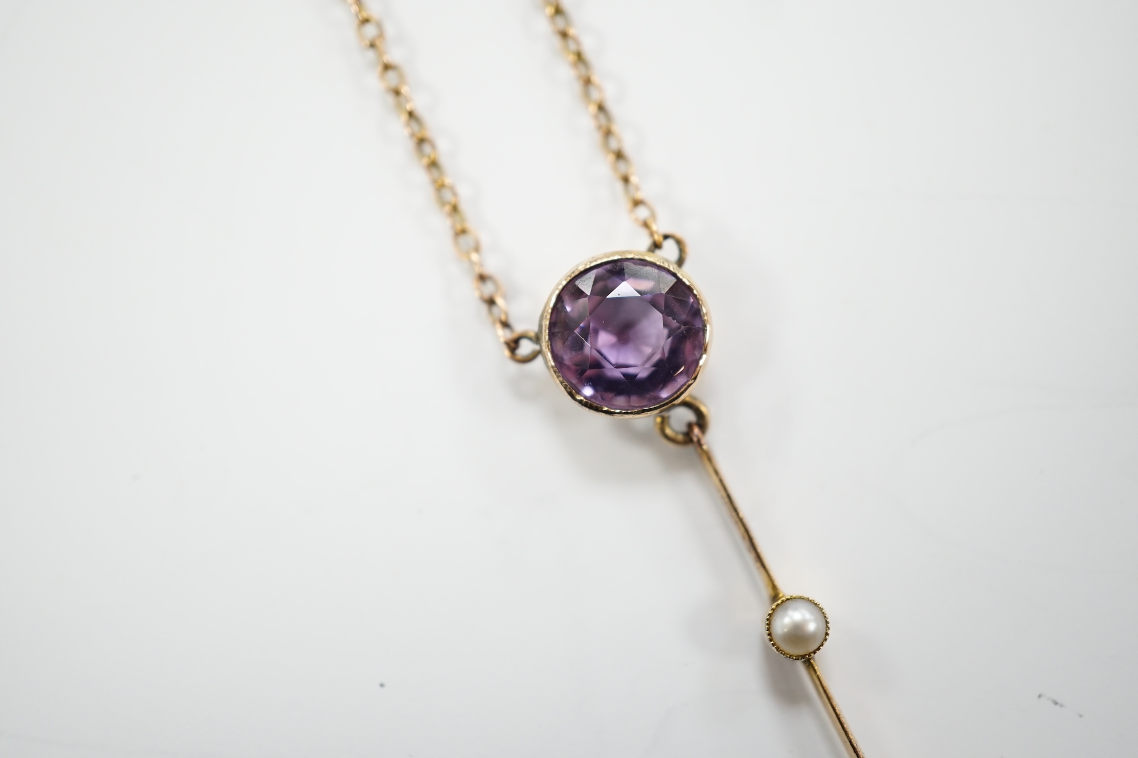 An Edwardian 9ct, two stone amethyst and single stone seed pearl set drop pendant necklace, gross weight 3.8 grams.